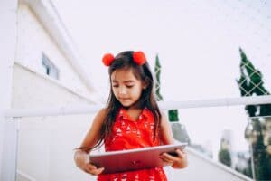 smart child browsing tablet on street